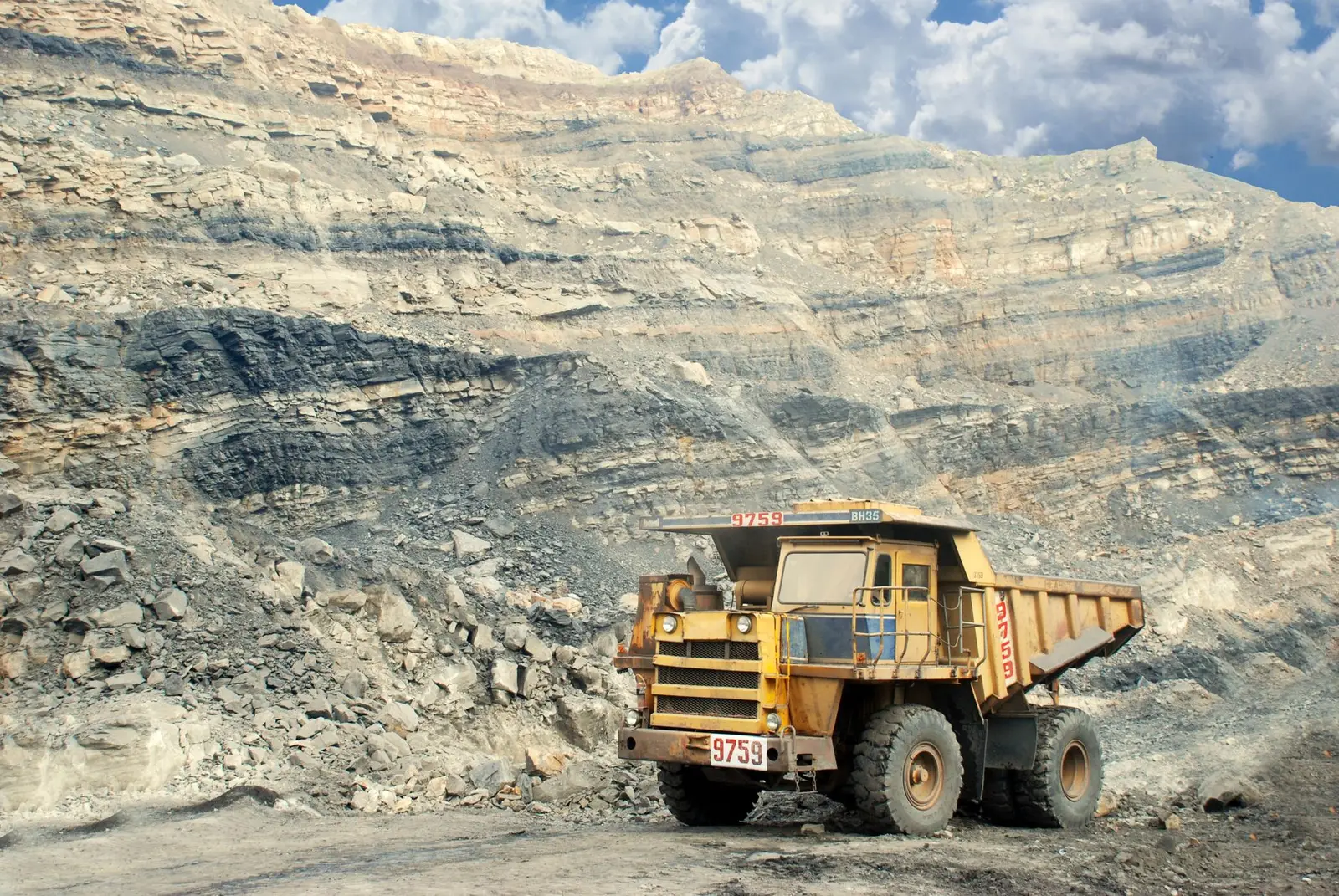 Yellow mining dump truck in an open-pit mine